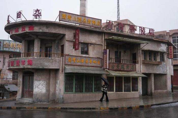 游客对照电影截图寻“同款” 《欢迎来龙餐馆》石头门楼成打卡点